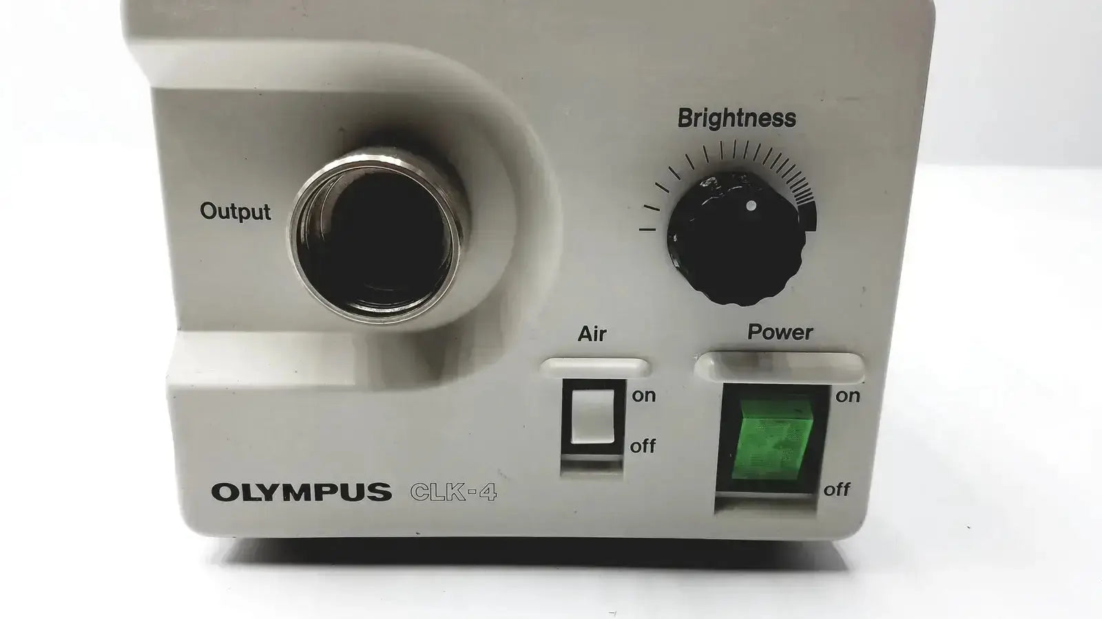 White olympus clk-4 dental halogen light source with metallic output port black brightness dial and green power indicator