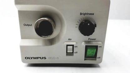 White olympus clk-4 dental halogen light source with metallic output port black brightness dial and green power indicator
