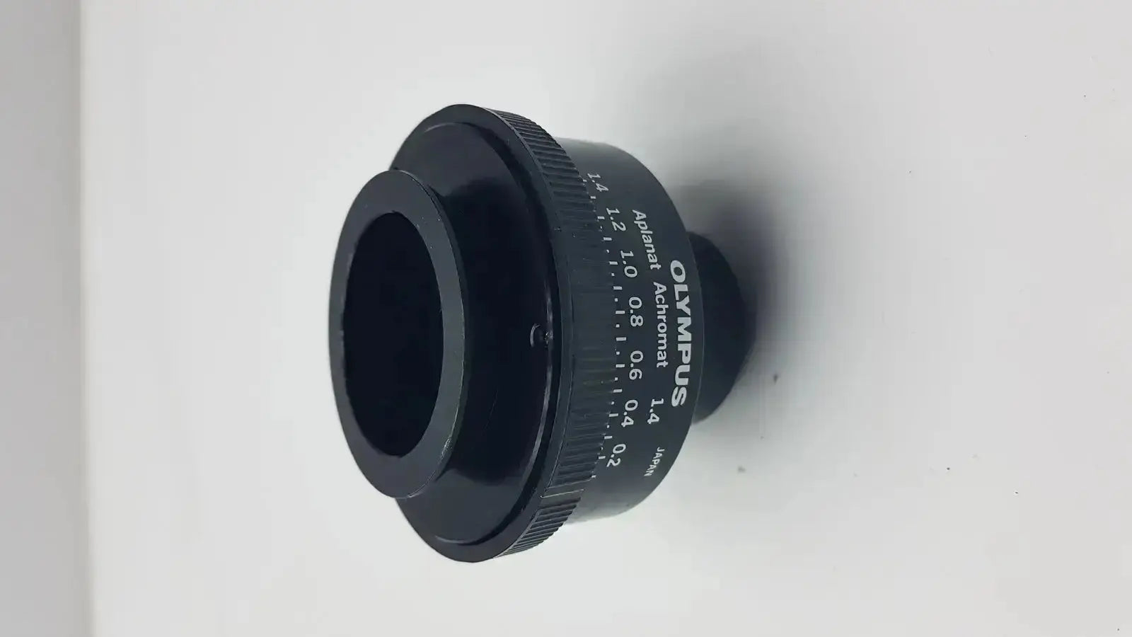 Black Olympus microscope condenser aplanat achromat 1.4 with engraved markings and textured focus ring adapter