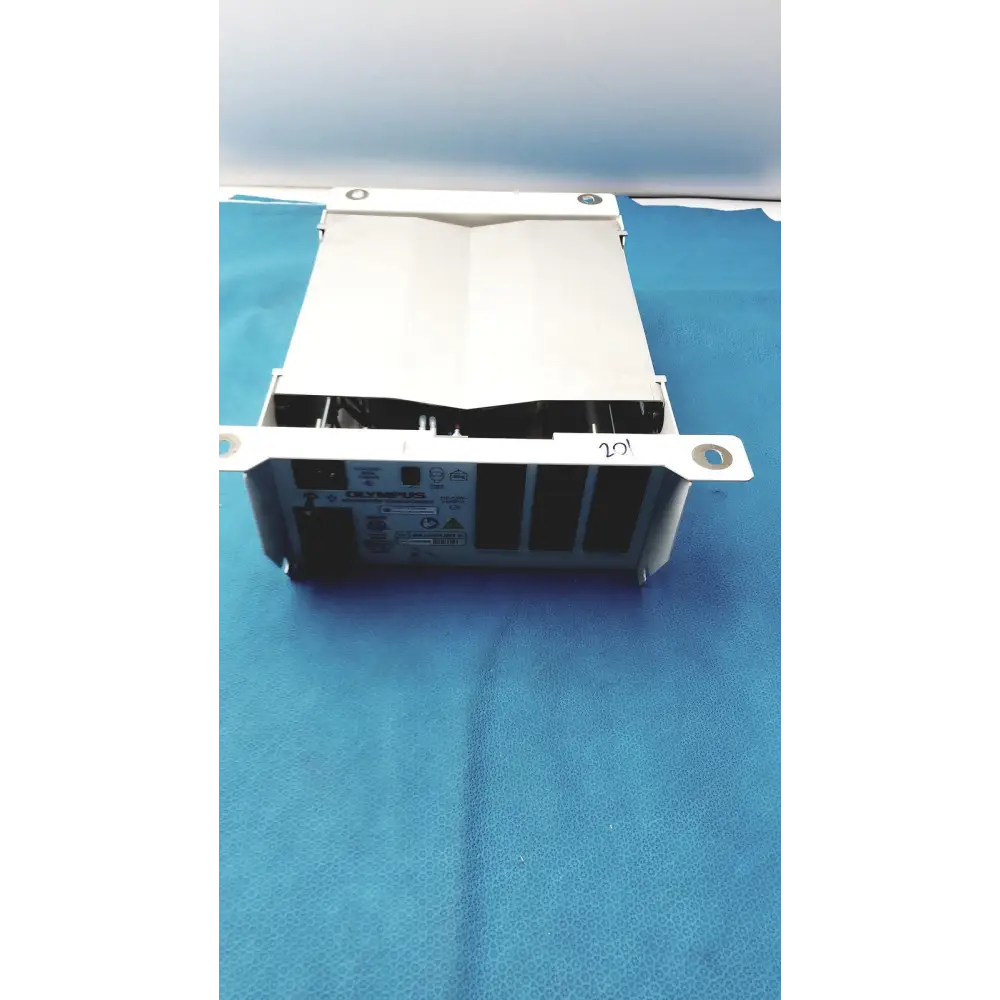White metal olympus medical device with a rectangular body and visible internal components.