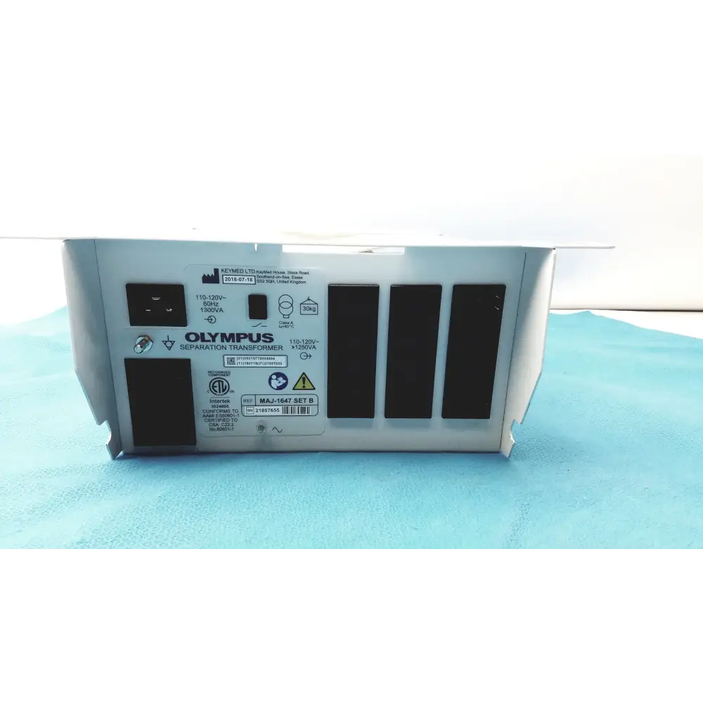 Silver metallic olympus separation transformer with black ventilation slits and labeled specifications on its rear panel.