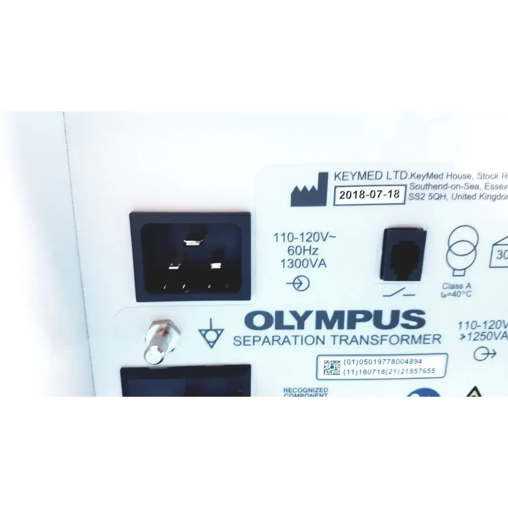 Olympus separation transformer with black power input socket and white label detailing specifications.