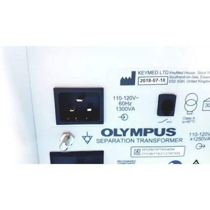 Olympus separation transformer with black power input socket and white label detailing specifications.