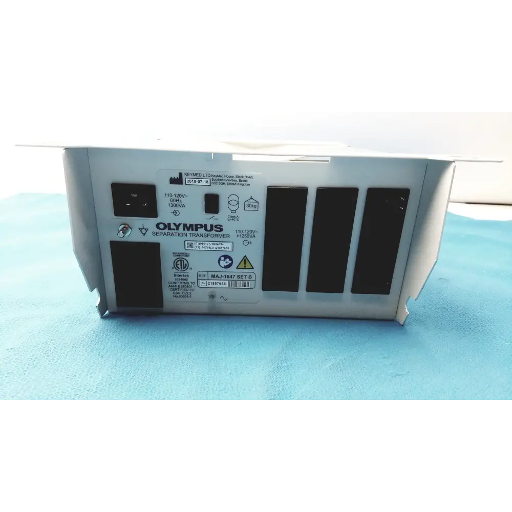 Silver olympus separation transformer with black ventilation slots and labeled specifications on its back panel.