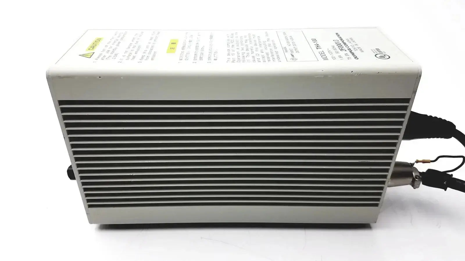 Gray rectangular Olympus TH4-100 100W 120V halogen power supply unit with ribbed front panel and black cables extending from side