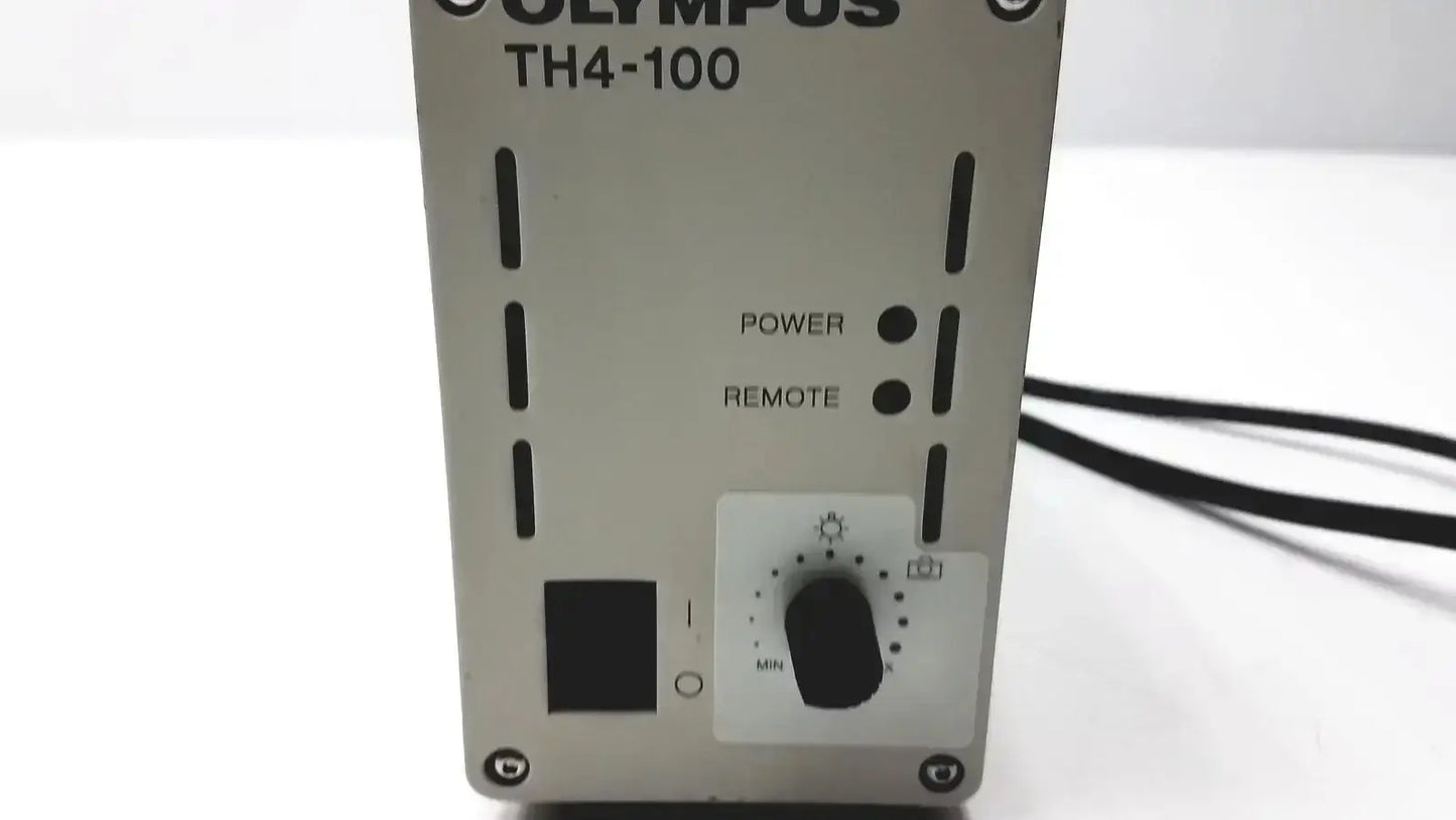 Silver olympus th4-100 camera flash unit with black power and remote buttons and white dial for halogen power supply
