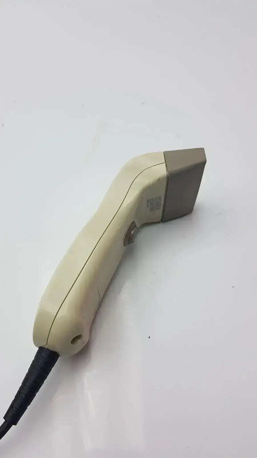 Cream-colored plastic opticon barcode scanner opt-1125 with gray scanning head and black cable for pre owned medical equipment sale