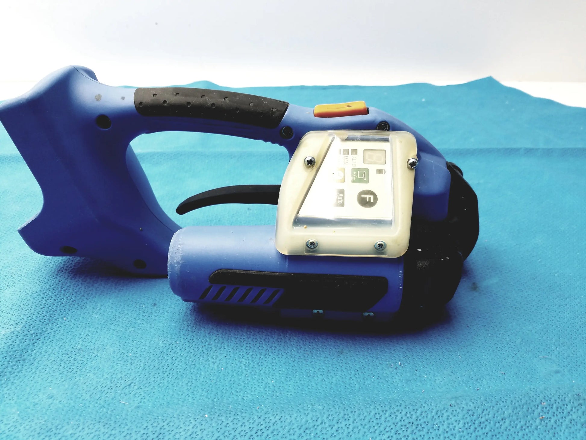 Blue plastic orgapack or-t 250 battery operated cordless strapping tool with black grip and beige control panel for reuse medical equipment