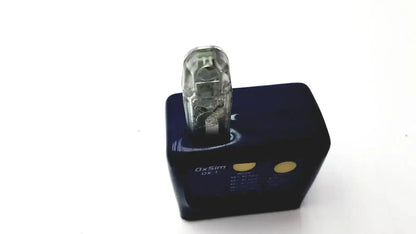 Clear plastic usb drive inserted into black charging dock with gold buttons on oxsim OX-1 pulse oximeter simulator