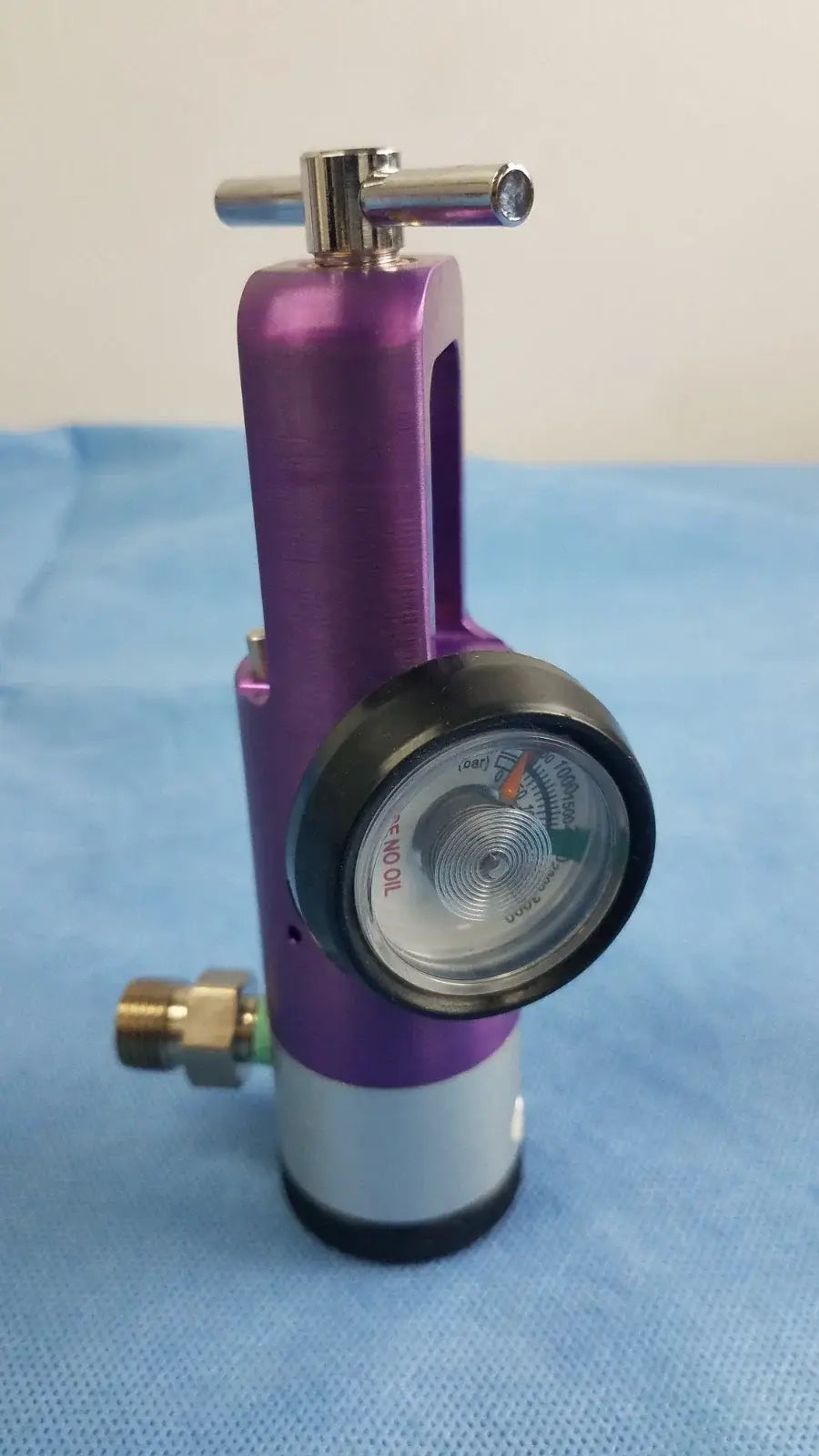 Purple and silver medical oxygen regulator with pressure gauge for precise medical gas flow control in medical equipment