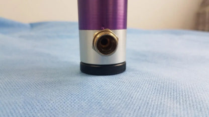 Purple and silver cylindrical oxygen regulator with brass threaded port for precise medical gas flow control in medical equipment