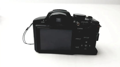 Black Panasonic model DMC-FZ35 digital camera with textured grip and visible control dials with Lumix battery charger