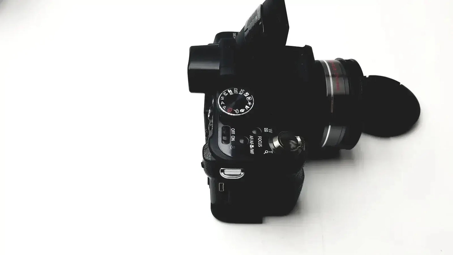 Black panasonic model dmc-fz35 digital camera with lens cap and manual control dials including lumix battery charger