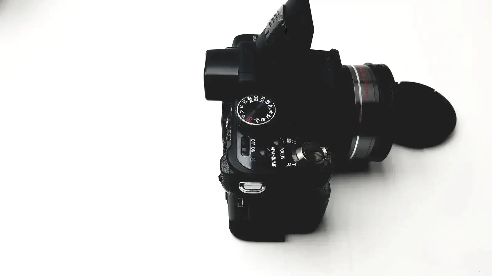 Black panasonic model dmc-fz35 digital camera with lens cap and manual control dials including lumix battery charger