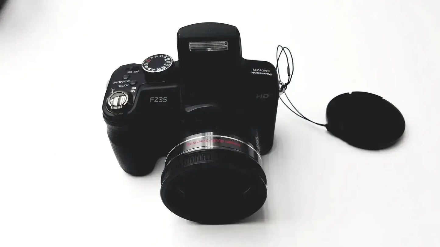 Black Panasonic Model DMC-FZ35 digital camera with lens cap beside it and Lumix DE-A43 battery charger