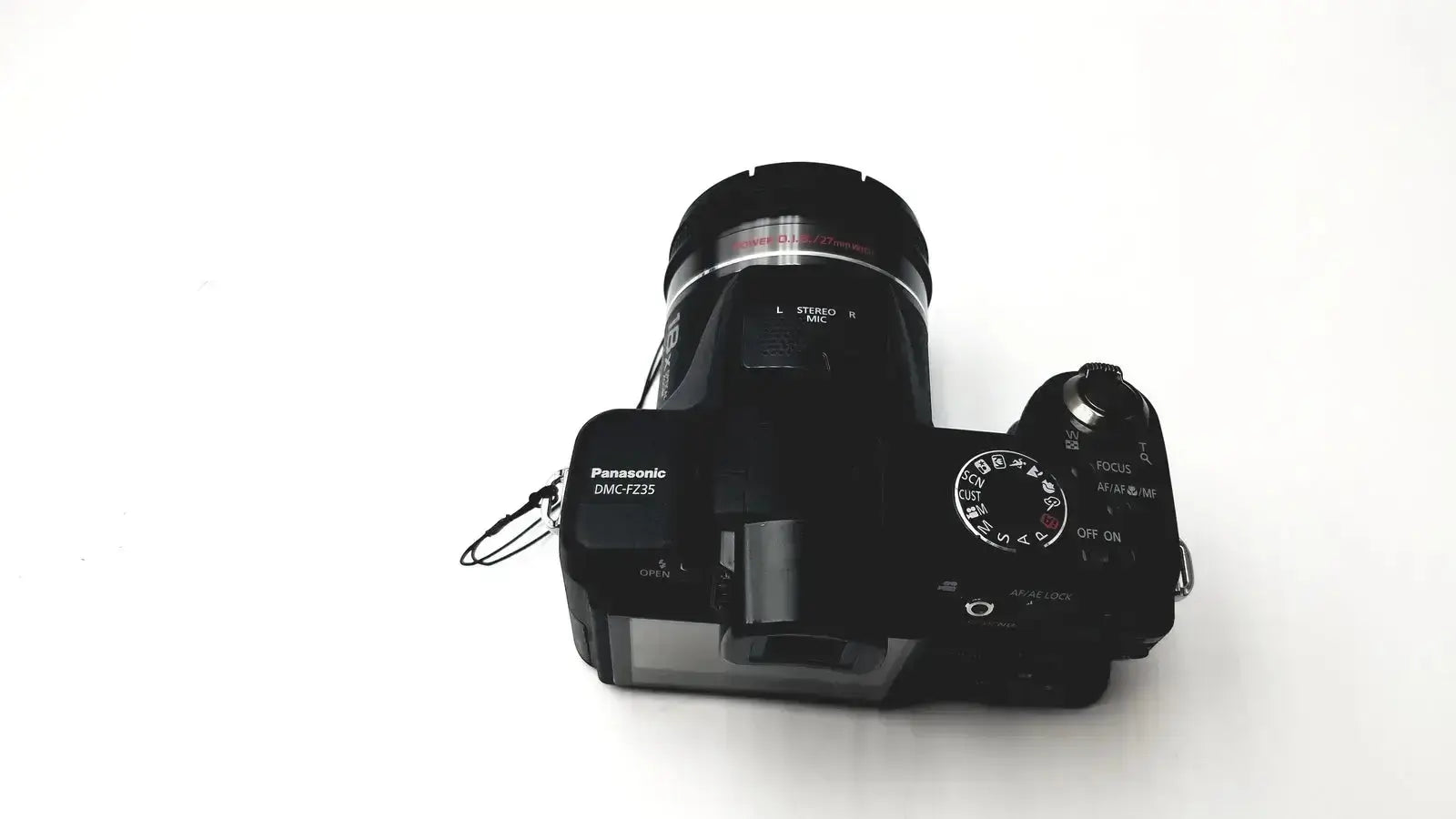 Black panasonic model dmc-fz35 digital camera with textured grip and control dials featuring lumix de-a43 charger