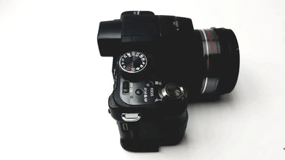 Black digital camera panasonic model dmc-fz35 with mounted lens textured grip and visible control dials with battery charger
