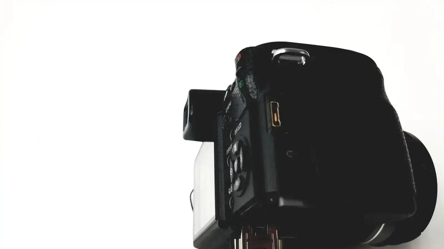 Black matte finish digital camera with control dials shown in panasonic model dmc-fz35 with lumix battery charger