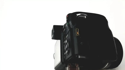 Black matte finish digital camera with control dials shown in panasonic model dmc-fz35 with lumix battery charger