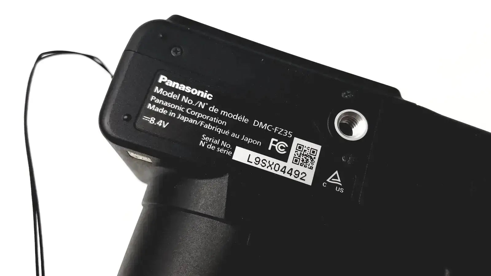 Black panasonic model dmc-fz35 digital camera body with matte finish and printed specifications label visible