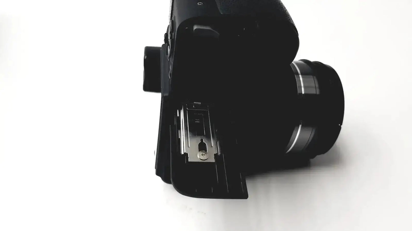 Black Panasonic model DMC-FZ35 digital camera with matte finish and silver accents on the lens barrel with battery charger