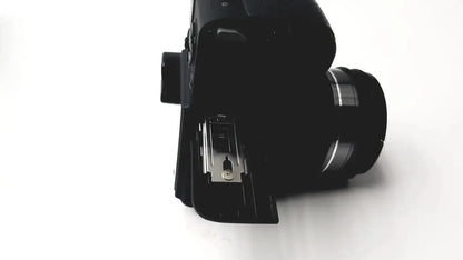 Black Panasonic model DMC-FZ35 digital camera with matte finish and silver accents on the lens barrel with battery charger