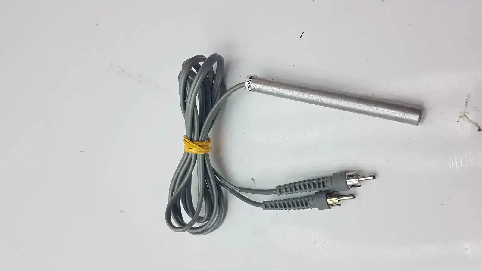 Gray coiled cable with two rca connectors and metallic probe tied by yellow band parks medical electronics mhz pencil doppler probe
