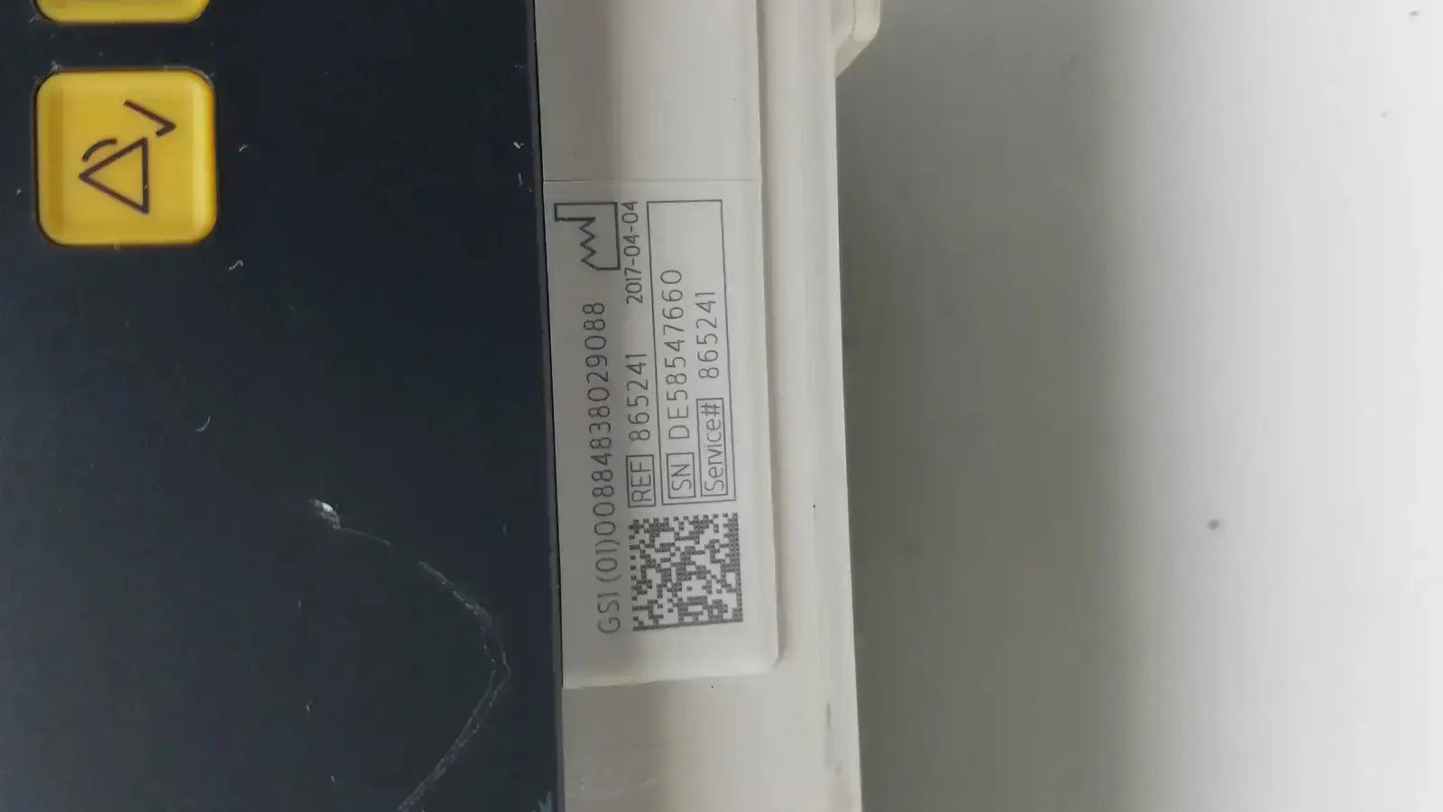 White plastic device label with black text and qr code on the back of philips intellivue mx700 bedside patient monitor
