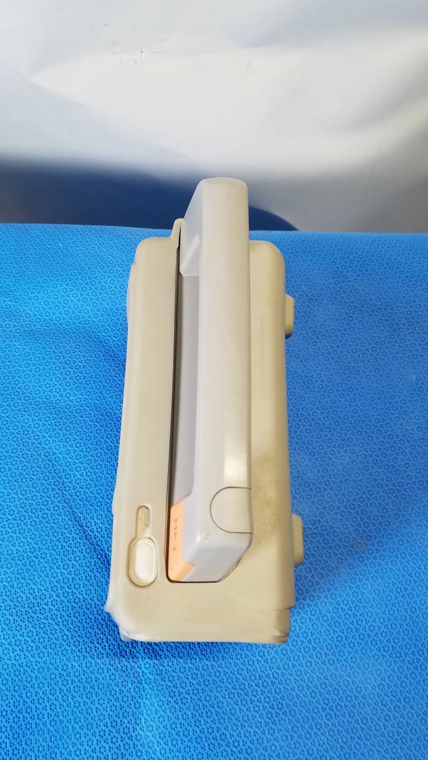Beige plastic philips intellivue mp2 portable patient monitor with sliding mechanism and orange accent medical equipment