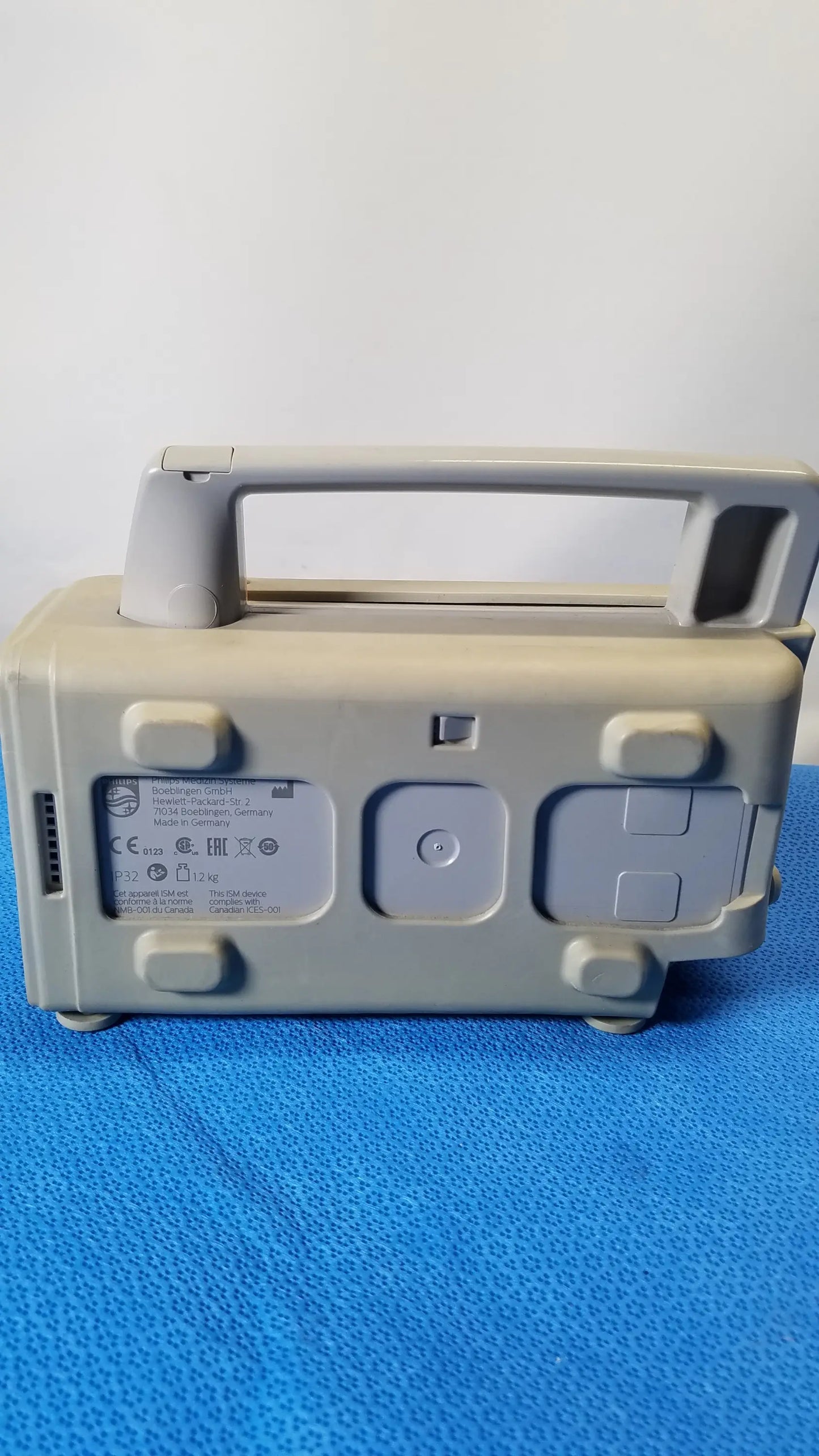 Gray plastic philips intellivue mp2 portable patient monitor with handle and multiple control buttons for medical equipment use