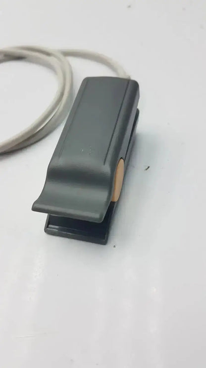 Black plastic foot pedal with beige button on the side of philips m1196t reusable adult spo2 clip sensor connector