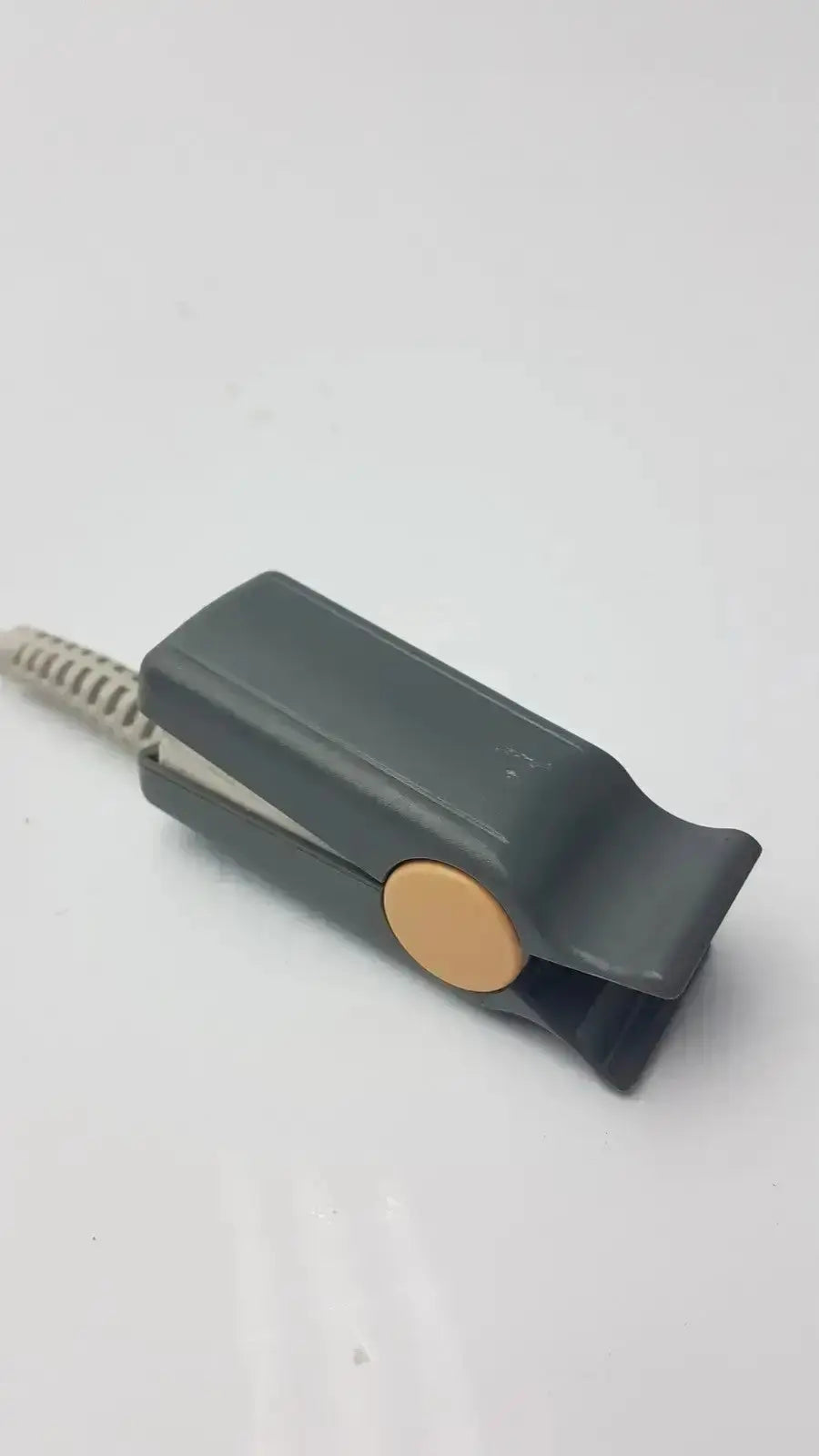 Gray plastic clip with tan button and textured cord of philips m1196t reusable adult spo2 sensor cable connector