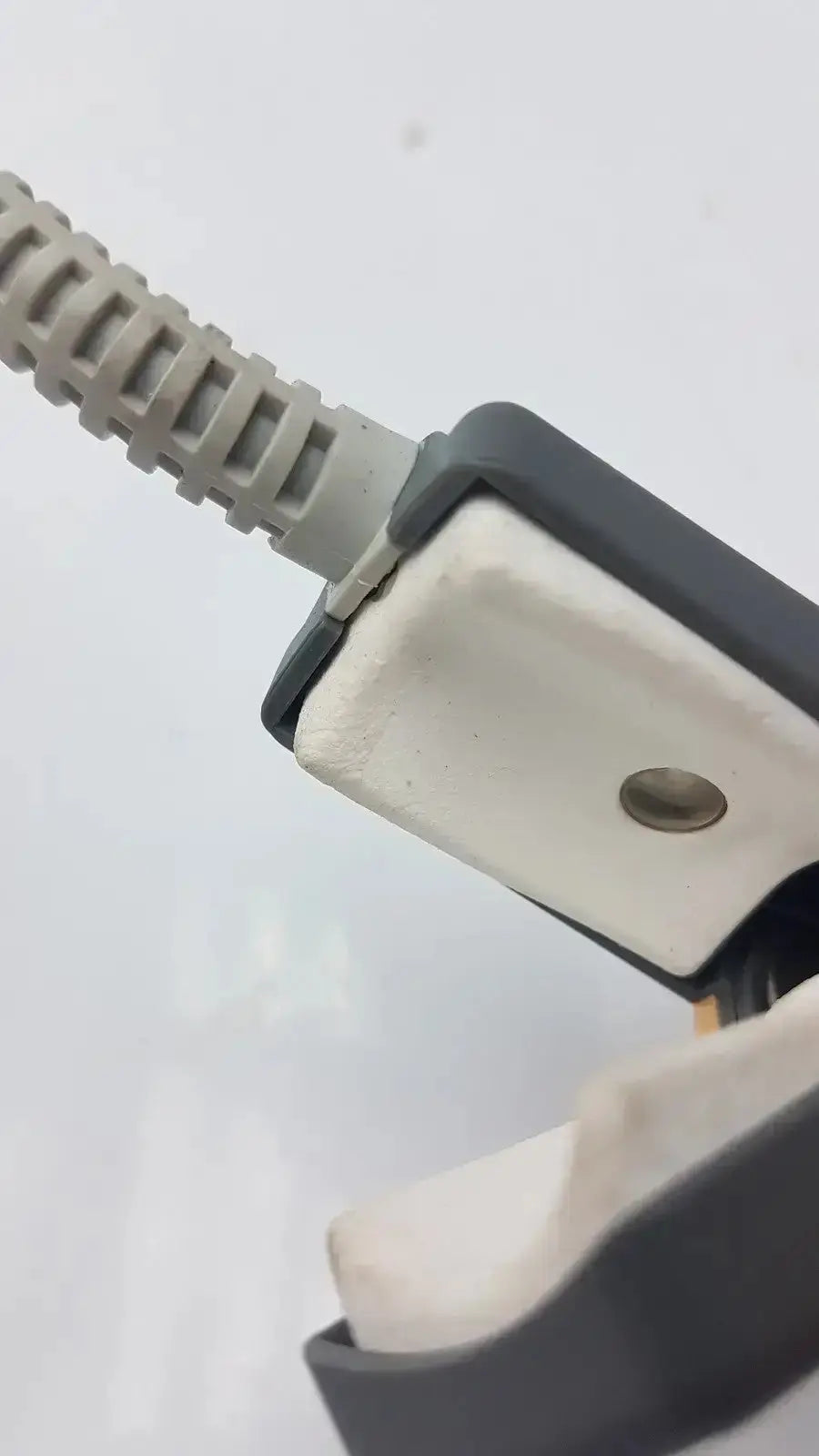 Gray coiled cable connected to black and white plastic connector of philips m1196t reusable adult spo2 clip sensor