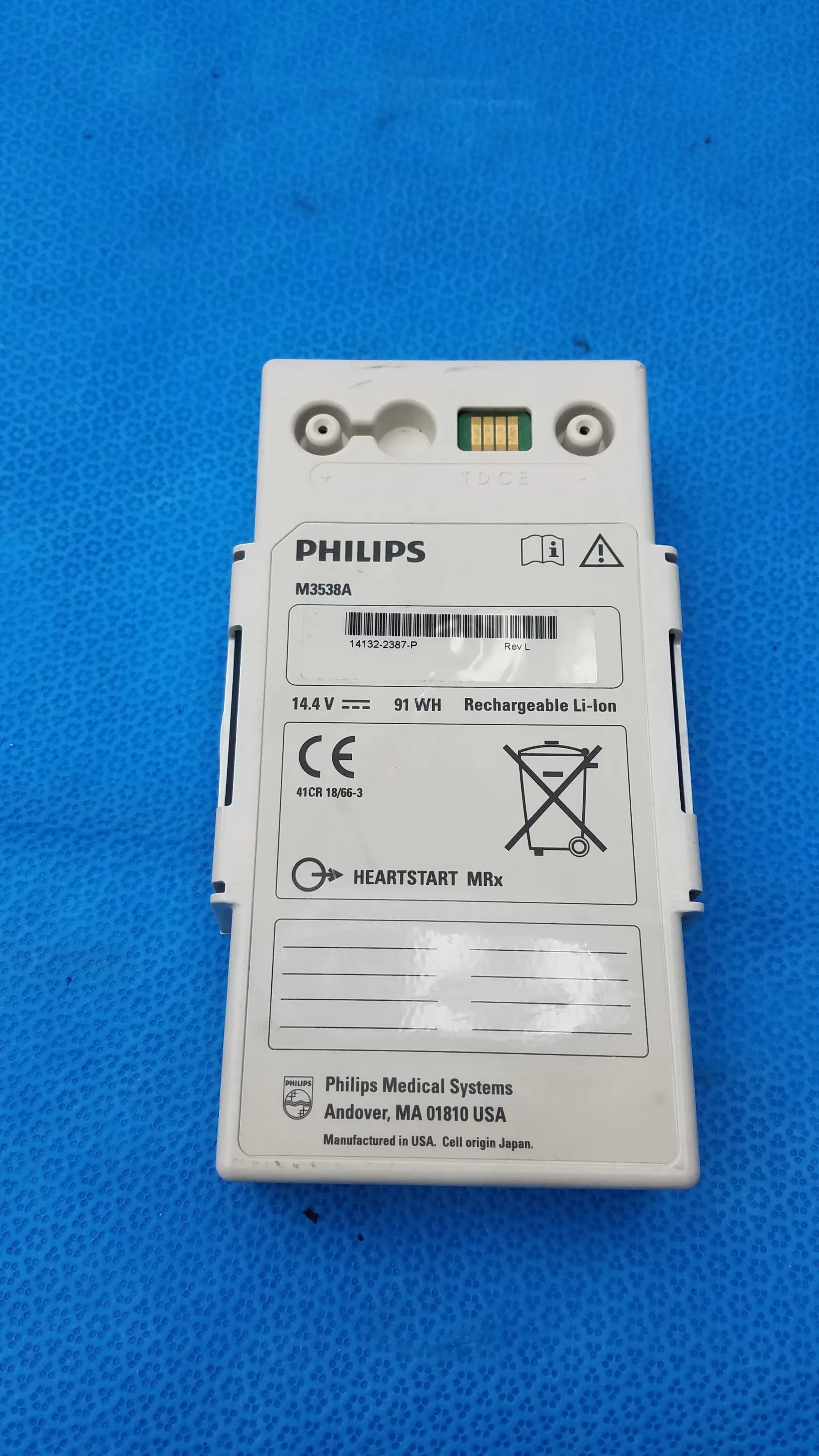 White philips m3538a heartstart mrx rechargeable lithium ion battery pack with green contact strip and black labels for medical equipment