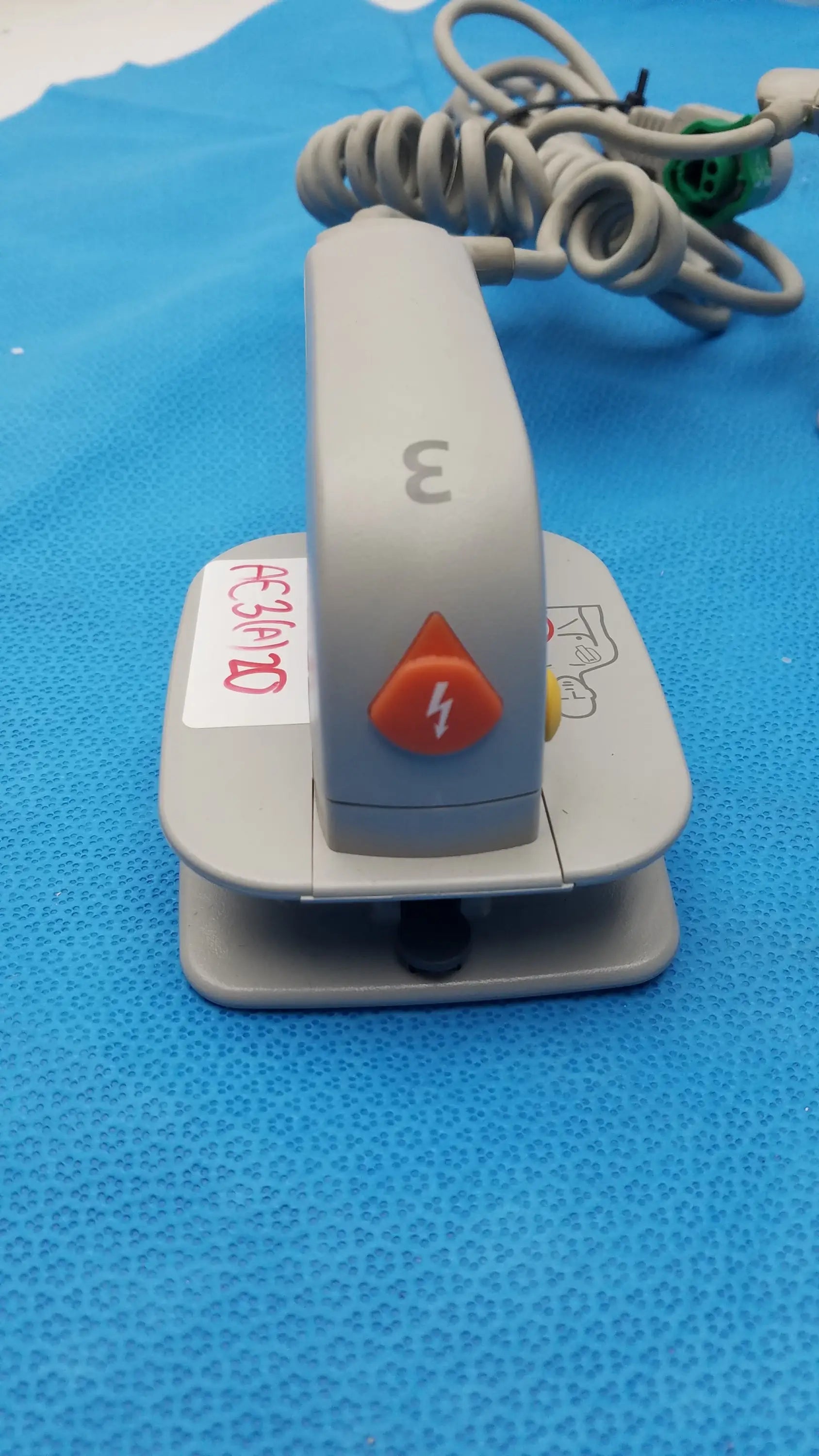 Gray philips m3543a water resistant external hard paddles medical equipment with orange power button and lightning bolt symbol