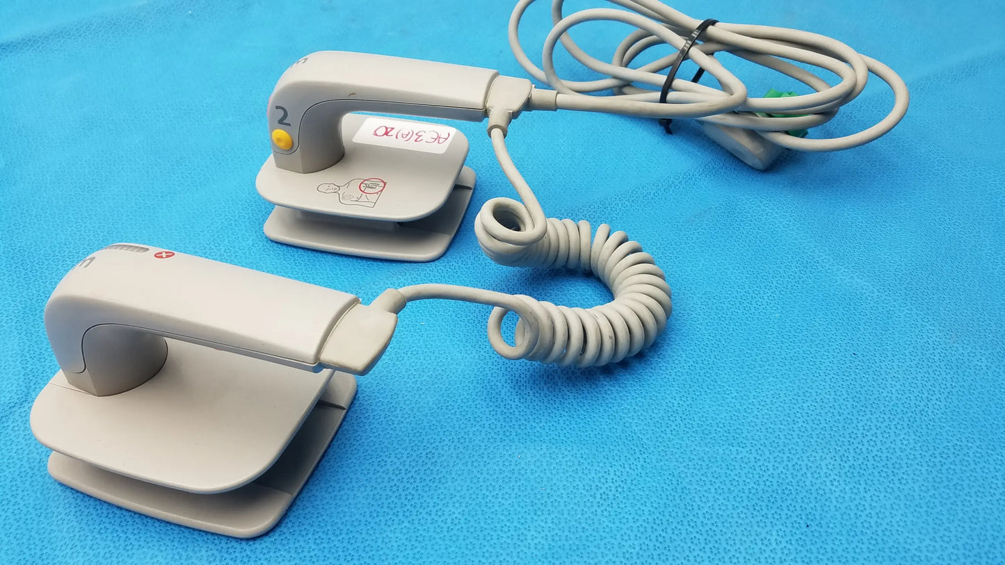 Gray plastic philips m3543a water resistant external hard paddles ecg electrode pads with coiled cables and yellow button medical equipment