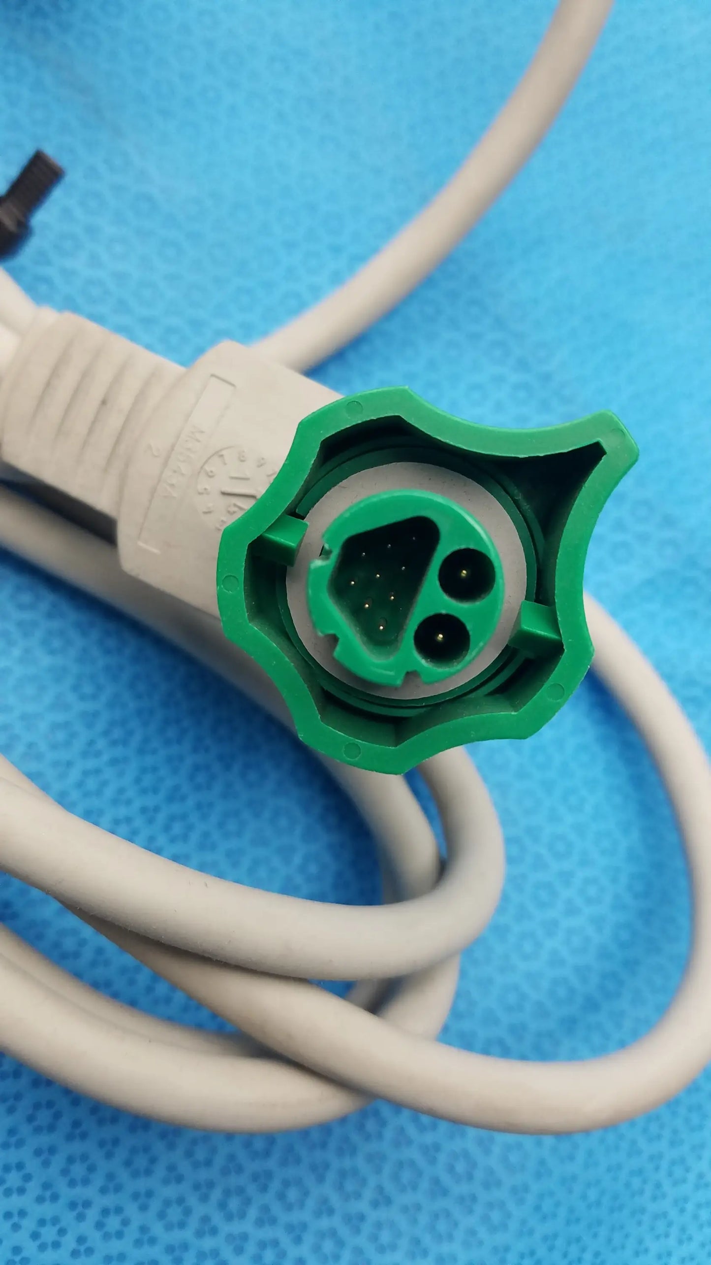 Green plastic shielded connector attached to beige cable of philips m3543a water resistant external hard paddles medical equipment