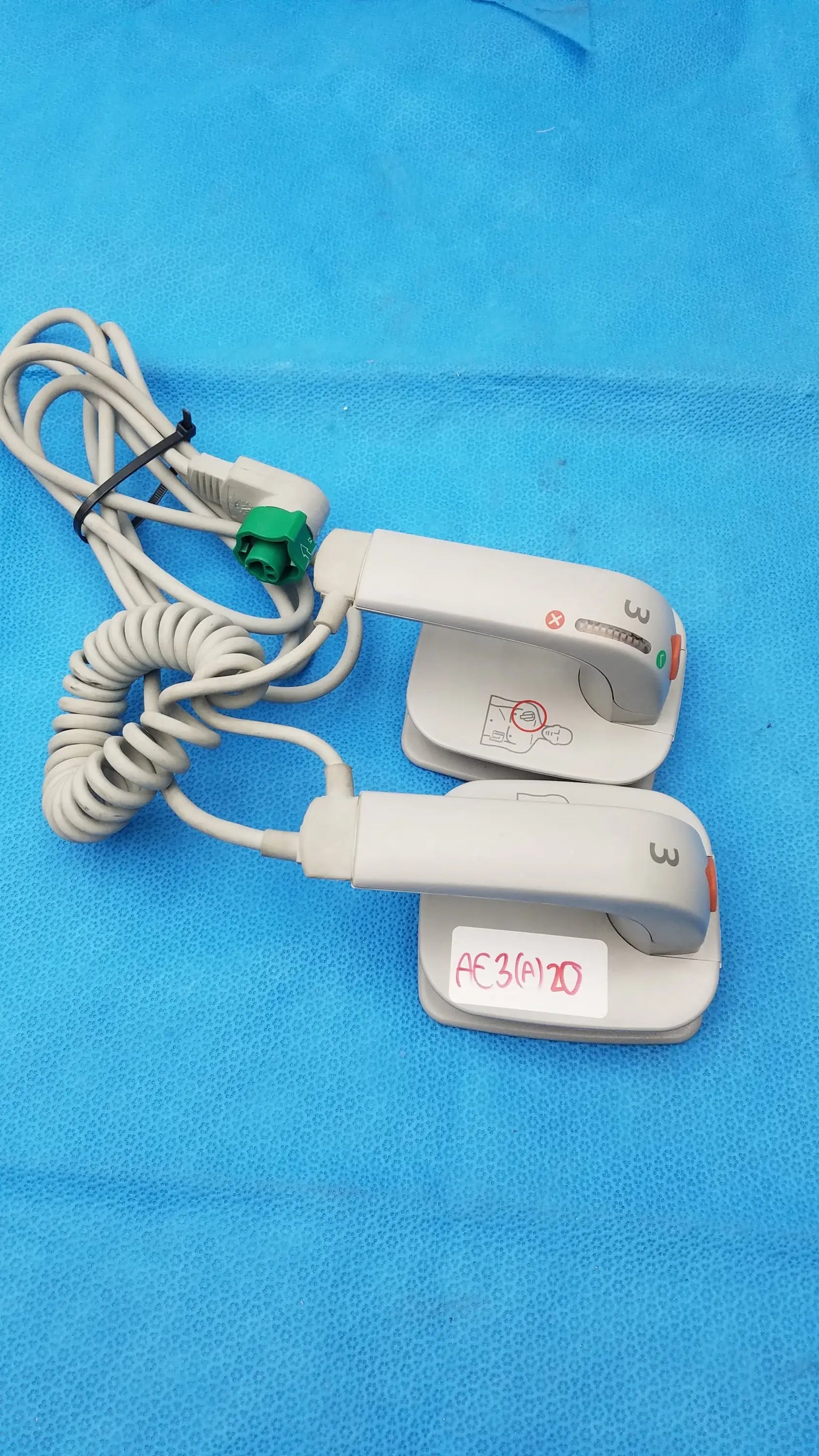 White plastic Philips M3543A water resistant external hard paddles with coiled cables and green connectors for medical equipment