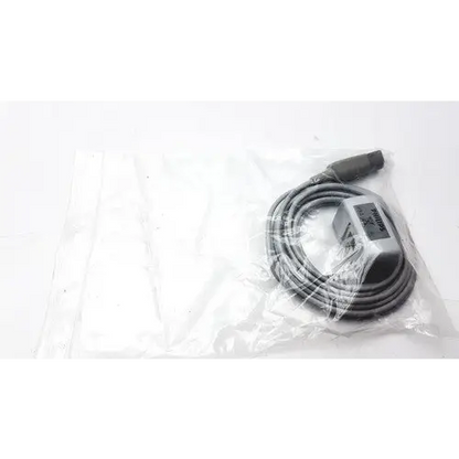 Gray coiled cable with a rectangular connector housing, wrapped in clear plastic packaging.