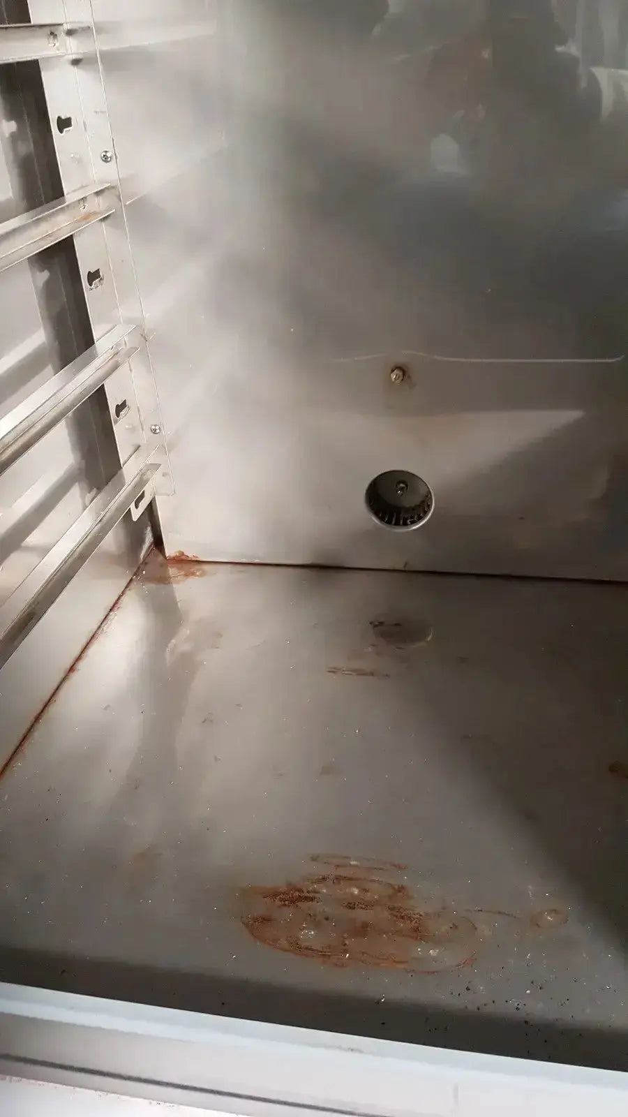Stainless steel interior of napco precision series co2 incubator with visible rust stains and circular drain hole