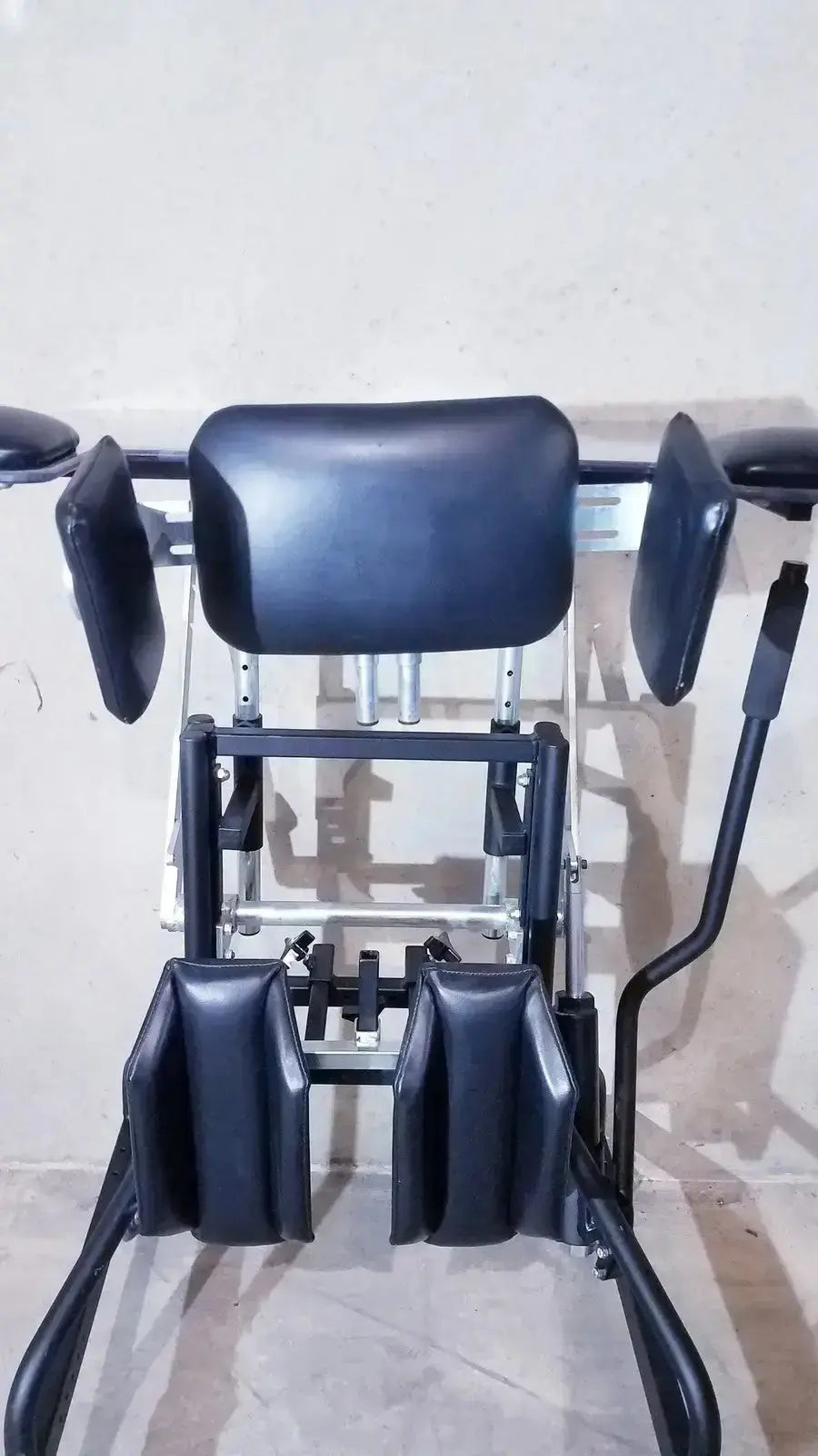 Black leather-backed gluteal and hip strengthening machine with adjustable metal frame in prime engineering grandstand iii modular standing system