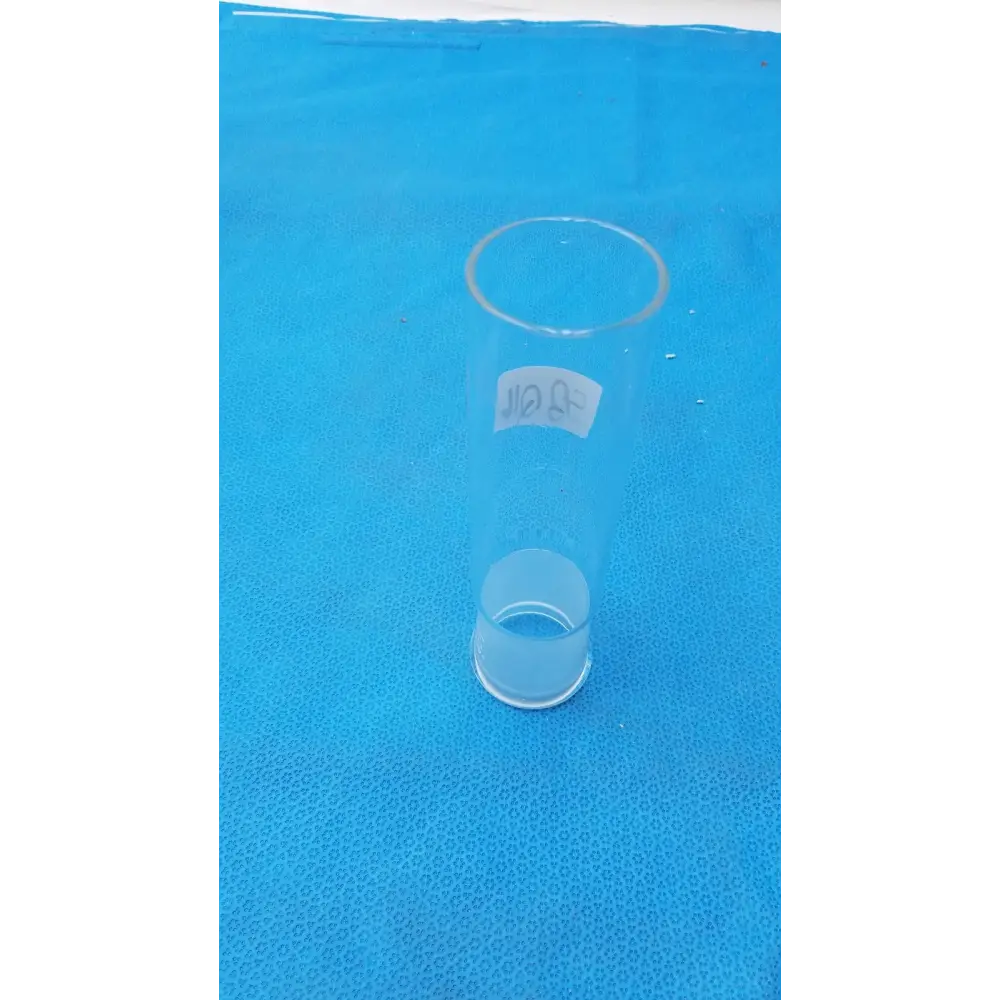 Clear glass graduated cylinder with a white label bearing thai script.