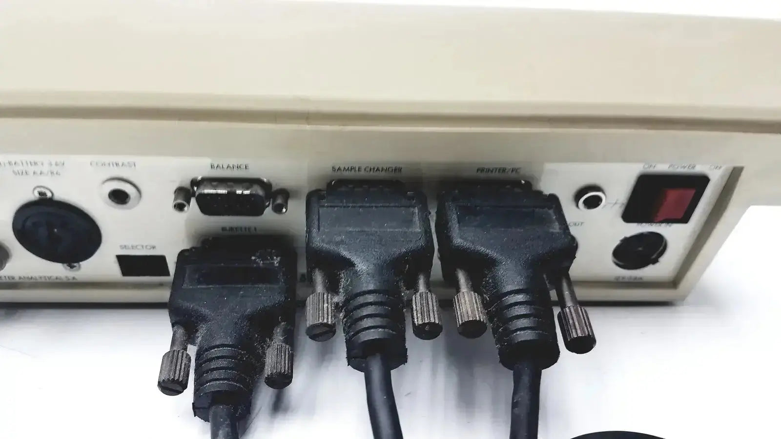 Black rugged cables with metallic thumbscrews connected to the beige rear panel of radiometer copenhagen tim900 titration manager