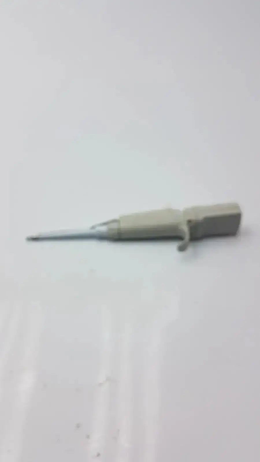 Gray plastic-handled screwdriver with metallic shaft used for maintenance of Rainin EDP3 Plus electronic digital pipette calibrated device
