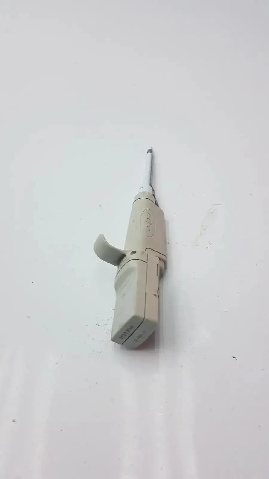 Beige plastic rainin edp3 plus electronic digital pipette calibrated with a slender metallic nozzle for precise dosing