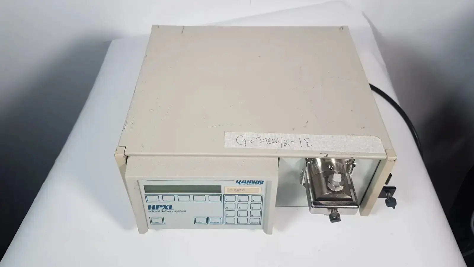 Beige rectangular rainin HPXL solvent delivery system with digital display keypad and metallic sample port for solvent delivery