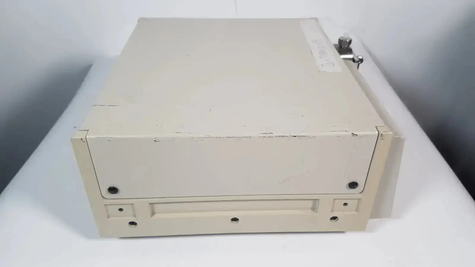 Beige metal file cabinet with lock and wear marks for secure storage in rainin hpxl solvent delivery system