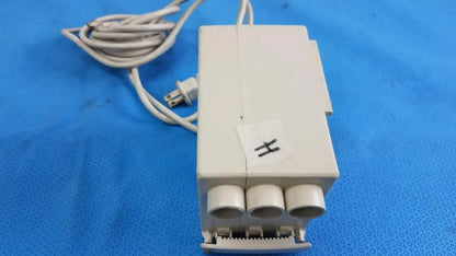 Off-white plastic raydow rd-b-24 control box with three cylindrical outlets and coiled beige cord for reuse medical equipment