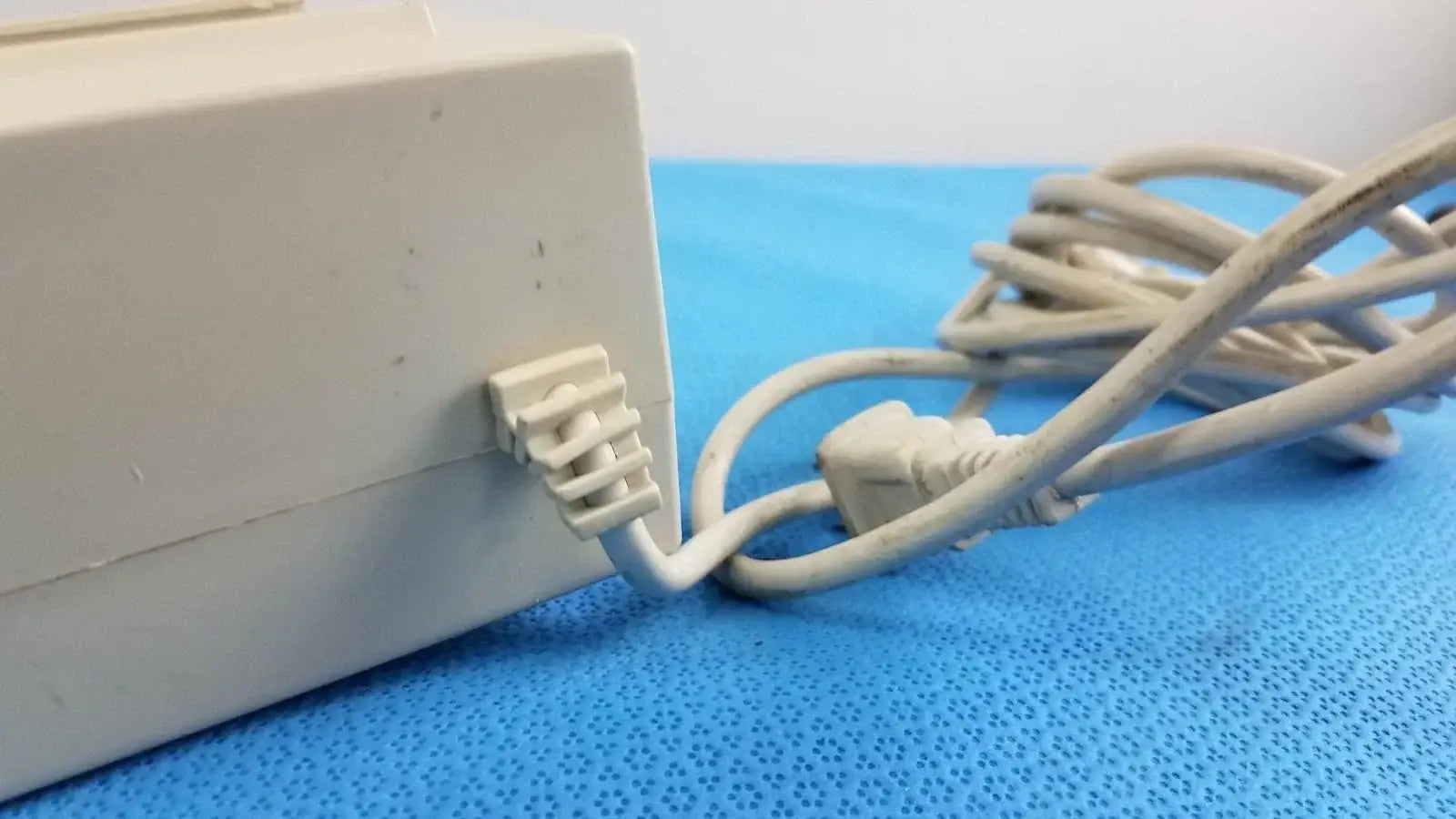 White plastic raydow rd-b-24 multi-function control box power adapter with coiled beige cable for reuse medical equipment