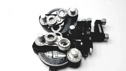Black and silver Reichert 11625 minus cylinder phoropter refracting instrument with multiple lenses dials knobs and damage